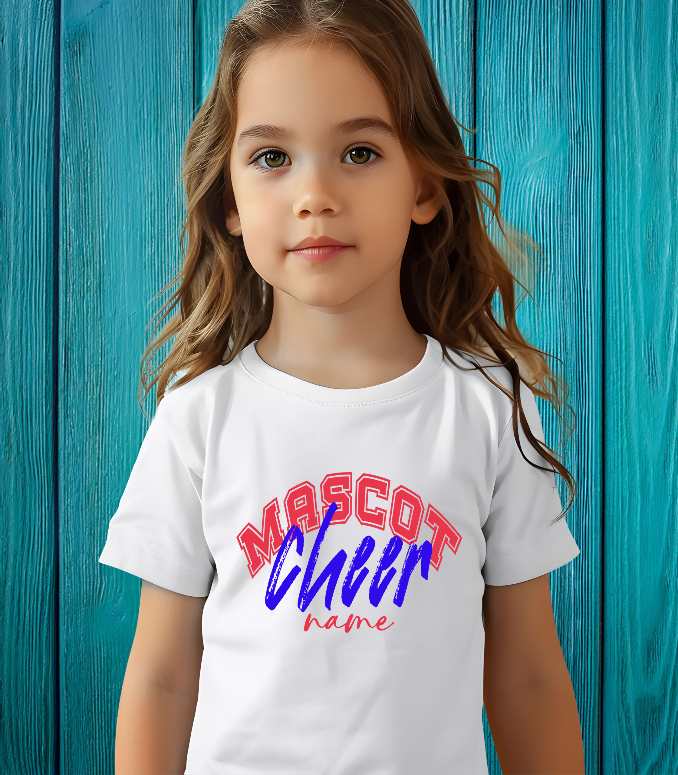 Young girl wearing a white custom cheerleading t-shirt with red, blue, and pink “Mascot Cheer Name” design, standing in front of a teal wooden background.