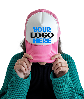 Person wearing a pink and white trucker hat with a customizable front panel displaying the text “Your Logo Here