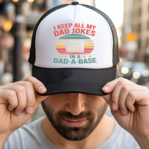White and black trucker hat with retro vintage graphic reading I Keep All My Dad Jokes In A Dad-A-Base with floppy disk – funny dad joke hat gift for fathers