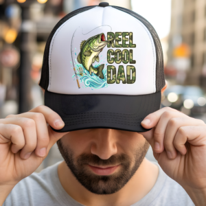 Black and white trucker hat with a custom "Reel Cool Dad" fishing design featuring a jumping bass, fishing rod, and camo-style lettering being worn by a Dad.