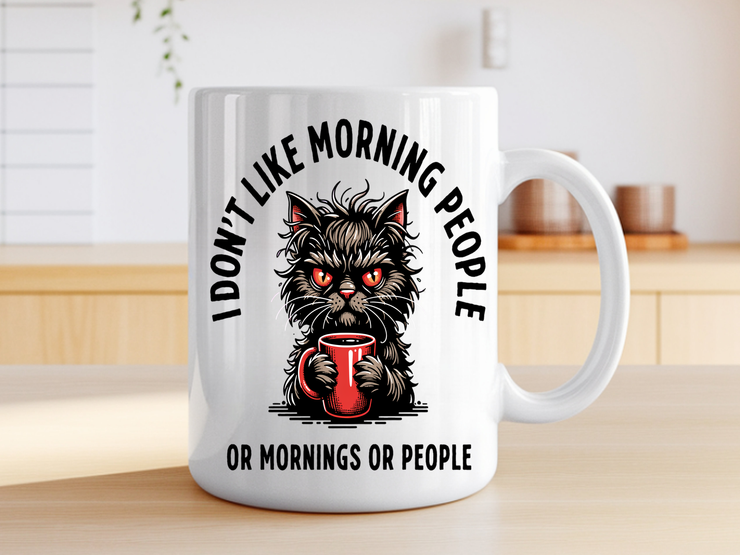 White ceramic coffee mug featuring an angry fluffy cat with glowing red eyes clutching a red coffee mug, with the text "I Don't Like Morning People Or Mornings Or People"