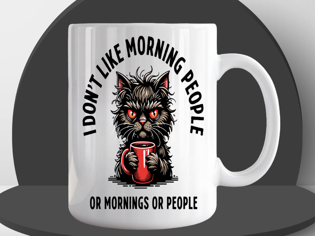 White ceramic coffee mug featuring an angry fluffy cat with glowing red eyes clutching a red coffee mug, with the text "I Don't Like Morning People Or Mornings Or People"