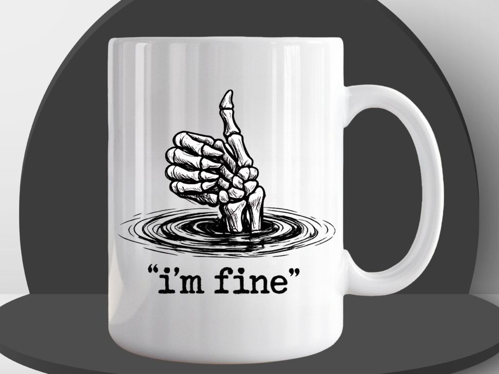 White ceramic coffee mug featuring a skeletal hand giving a thumbs up while sinking into water, with the text "i'm fine" in quotation marks on a black podium