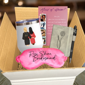 Personalized bridesmaid proposal gift box featuring an insulated custom bridal party wine tumbler, gray faux leather floral journal and pen, pink satin sleep mask reading Rise Shine Bridesmaid, and a photo strip proposal card.